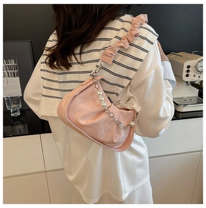 Detail of pink ruched shoulder bag with large pearl strap and silver chain accents