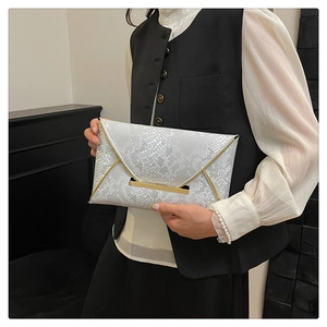 Detail of white snake pattern envelope clutch with gold metal edge trim for women