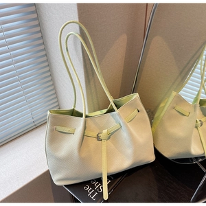 Detail of mint green woven tote bag with adjustable strap and decorative buckle