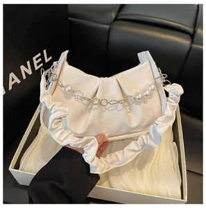 Détail du sac nuage crème avec bandoulière à volants et chaîne à perles et fleurs