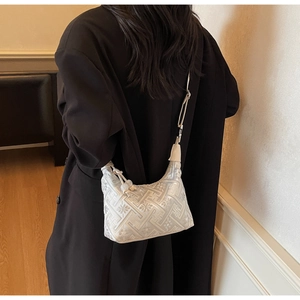 Détail du sac hobo en jacquard argenté avec motifs floraux et bandoulière en cuir