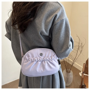 Detail of lavender pleated crossbody bag with metal M logo and soft nylon texture