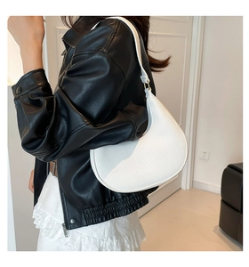 Detailed view of the white crescent bag with lychee texture leather on model