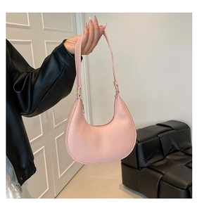 Detailed macro view of pink crescent bag showing high-quality lychee grain leather texture