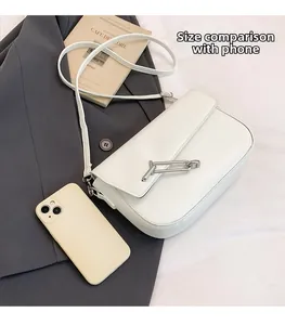 Detailed size comparison of a white saddle bag next to a smartphone on a blazer