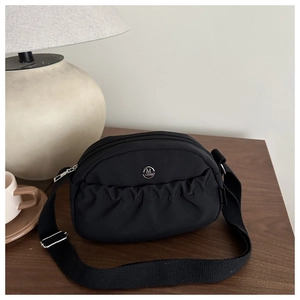 Detail of black nylon crescent bag with ruched pocket and silver metal M logo