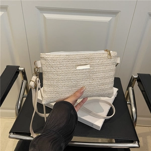 Minimalist woven straw crossbody bag in cream with metal zipper and slim shoulder strap