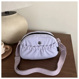 Detail of light purple nylon crossbody bag with metal logo and pleated design