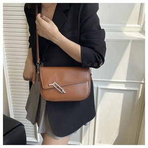Brown leather half-moon shoulder bag with geometric silver buckle and sleek minimalist design