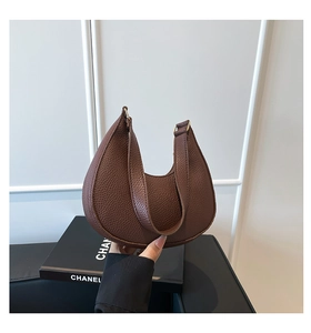 Close-up of brown litchi grain leather hobo bag with elegant gold metal buckle detail