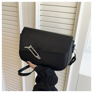 Detail of black leather underarm bag featuring a unique silver metal ring buckle closure