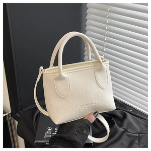 Detail of white lychee pattern bucket bag with handles and embossed brand logo