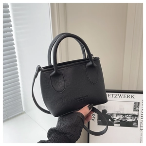 Detail of black lychee grain leather mini bucket bag with fashion embossed logo