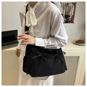 Détail du sac fourre-tout plissé noir avec double nœud et bandoulière réglable