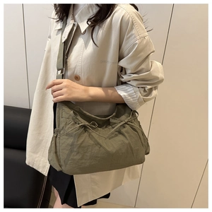 Détail du sac fourre-tout en nylon plissé vert armée avec nœud de serrage et sangle