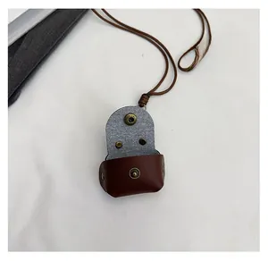 Macro shot of deep brown leather mini pouch with copper snap button and woven lanyard