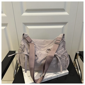 Détail du cabas plissé lilas avec cordon de serrage latéral et large bandoulière