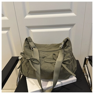 Détail du sac fourre-tout plissé vert foncé avec deux nœuds et une large bandoulière
