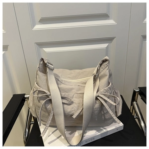 Vue détaillée du sac cabas plissé avec rubans sur une chaise noire et magazine