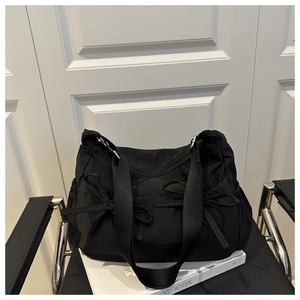 Détail du grand sac cabas en nylon noir avec nœuds décoratifs et cordon de serrage