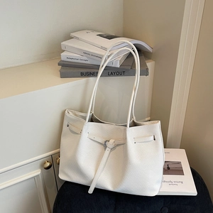 White woven leather tote bag with buckle detail and long handles for daily commuting