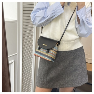 Detail of colorful rainbow woven straw crossbody bag with black leather flap and gold logo