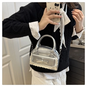 Silver mini bowling bag featuring a bow accent, lace trim, and a detachable chain strap