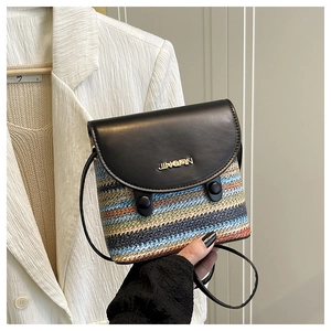 Detail of colorful striped woven crossbody bag with black leather flap and gold logo
