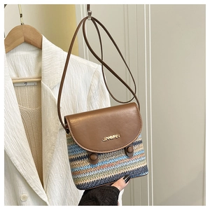 Detail of a rainbow woven crossbody bag with brown leather flap and golden logo