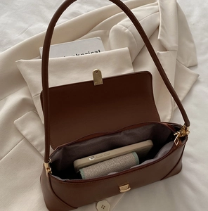 Detailed interior of a brown baguette shoulder bag showing phone and wallet capacity