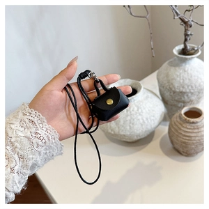 Détails de la mini pochette en cuir noir pour écouteurs avec bouton doré et lanière
