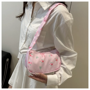 Detailed shoulder view of pink floral printed underarm bag with bow decoration