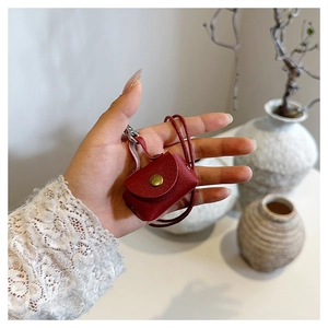Détail de mini pochette rouge en cuir pour écouteurs avec grain lychee et bouton