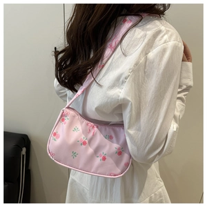 Detail of pink floral shoulder bag with delicate bow patterns and drawstring design