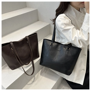 Detailed comparison of large black and dark brown matte leather tote bags on steps