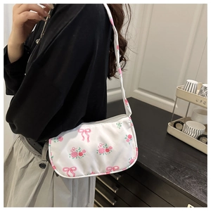 Floral shoulder bag with pink rose patterns and bow details shown in use