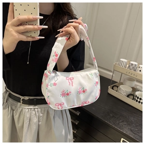 Detail of white nylon tote bag with pink rose patterns and bow prints in home setting
