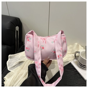 Detail of pink floral handbag featuring rose and bow prints with matching fabric straps