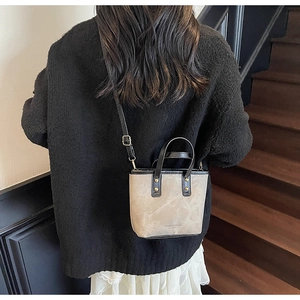 Détail du sac cabas bicolore avec texture marbre et bandoulière en cuir noir