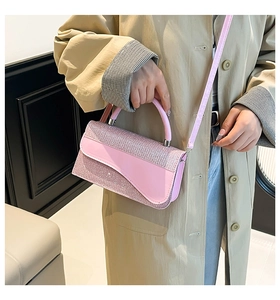 Détail d'un sac à main rose avec strass brillants, rabat ondulé et bandoulière en cuir assortie