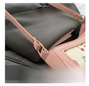 Dettaglio ravvicinato della borsa rosa con ciliegie, fibbie oro e cuciture fini