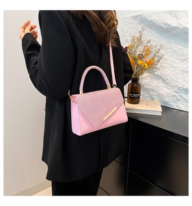 Detail of pink sequin shoulder bag with golden metal trim and sleek leather finish