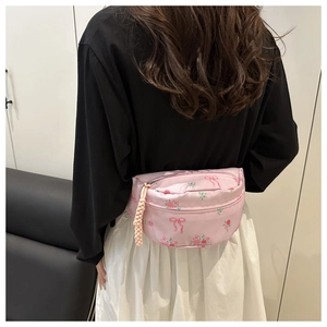 Détail du sac banane rose en nylon avec motifs floraux et cordon de fermeture éclair