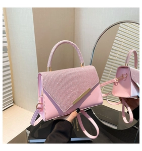 Detail of pink glitter texture and glossy leather on the handbag with gold metal accents