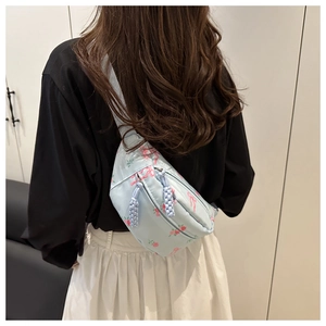 Détail du sac en nylon bleu clair avec motif floral rose et tirette de zip tissée
