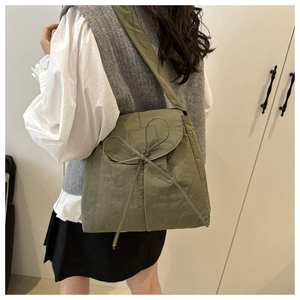 Detail of olive green ballet-style crossbody bag with delicate bow knot ribbon decoration