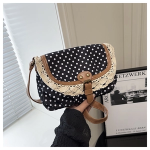 Detail of vintage polka dot crossbody bag with white lace trim and brown faux leather strap