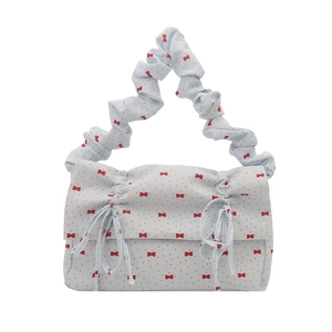 Hellblaue Stofftasche mit rotem Schleifenmuster und stylischem gerafftem Griffdesign
