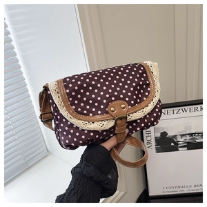 Detail of vintage polka dot crossbody bag with beige lace trim and adjustable strap