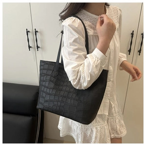Detailed close-up of black crocodile embossed texture on a large capacity tote bag